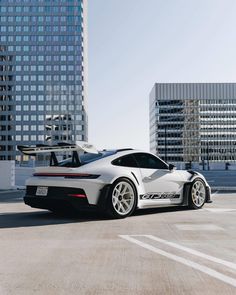 a white sports car parked in front of tall buildings