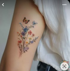 a woman's arm with flowers and butterflies on it