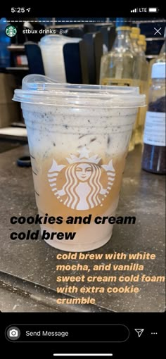 a starbucks cup with cookies and cream cold brew on the side, sitting on a counter