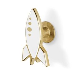 a white and gold rocket ship hook on a wall