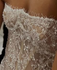 the back of a woman's dress with white flowers on it and lace overlays