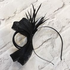 Lovely black fascinator, perfect for a wedding guest or bridesmaid headpiece. Created from black sinamay and trimmed with black biot feathers, with silver beads.   Mounted on a black metal headband. This design can also be made on a comb if required.  A beautiful addition to complete your outfit for a wedding, or day at the races  This design can be made in various colours to match your outfit. Please contact me for a custom order Adjustable Black Feather Headpiece, Adjustable Black Feathered Headpiece, Evening Fascinator With Feather Trim And Adjustable Fit, Evening Fascinator With Adjustable Feather Trim, Black Feather Headband For Parties, Black Sinamay Fascinator For Wedding, Black Feathered Party Headband, Black Feathered Headband For Party, Black Feathered Headpiece For Evening