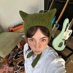 a young woman wearing a knitted hat and scarf with an animal head on it