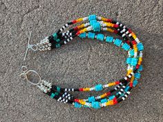 multicolored beaded bracelets with silver clasp on concrete surface in urban setting