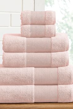 a stack of pink towels sitting on top of a wooden table