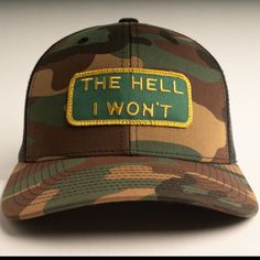 *Back ordered 1 month* "The Hell I Won't" Trucker Hat - a declaration of unstoppable determination with a twist of irreverence. Constructed from a durable blend of 70% Polyester and 30% Cotton, embodying the iconic trucker style with a snapback design. One size fits most adventurers - Inside circumference measures 24 inches at its fullest extension (about size 7-8). Features a padded sweatband and an adjustable snapback with seven snaps for a customizable fit. Assembled with pride in Dallas, TX Hillbilly Hat, Camo Trucker Hat, Custom Trucker Hats, Keep On Truckin, Funny Hats, Funny Men, Gift Inspo, Outfits With Hats, 1 Month