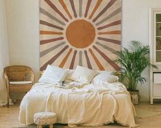 a bedroom with a large sun painting on the wall