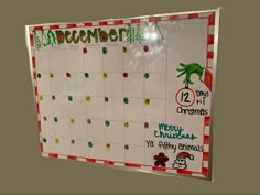 a christmas calendar is hanging on the wall in front of a bulletin board that says december