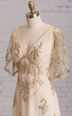 a white dress on a mannequin with gold embroidered flowers and sequins