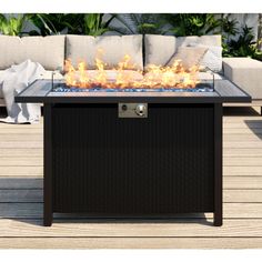 a fire pit sitting on top of a wooden deck next to a couch and table