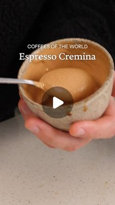 a person holding a bowl filled with liquid and spoon in their hands, while the words espresso crema are written below