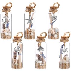 four glass bottles filled with sand and shells