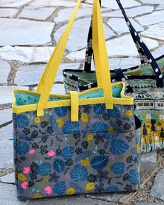 two purses sitting on the ground next to each other