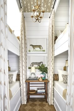 a room with bunk beds and curtains on the walls, two lamps hanging from the ceiling