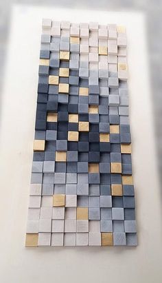 a white table topped with lots of gray and gold squares on top of each other