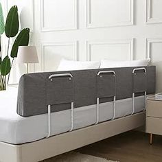 a bed that has been made and is in the middle of a room with white walls