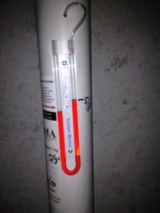 a fire extinguisher hanging on the side of a wall with an orange handle