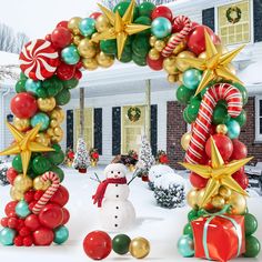 a snowman and christmas decorations in front of a house decorated for the holiday season