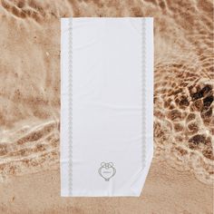 a white towel with a dog paw on it laying in the sand