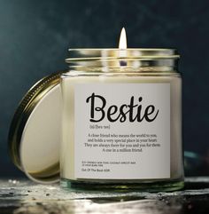 a candle with a label on it sitting next to a jar that says bestie