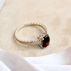 a close up of a ring with a stone in the middle on a white cloth