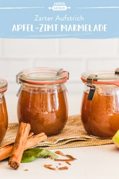 three jars filled with apple - zimt marmelade on top of a table