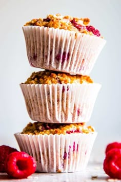 three muffins stacked on top of each other with raspberries around them