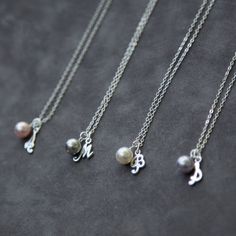 four different necklaces with charms on them