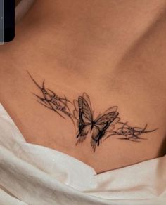 a woman with a butterfly tattoo on her chest