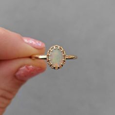 This antique style crown ring comes with a gorgeous Australian oval opal. If you want a different stone or want to add accent diamonds contact us for a quote. Details: - Default stone size is 7x5mm Australian Opal in oval shape. - Shiny finish by default. - Default width is 1.8mm at the bottom and 8.7x6.5mm at the top - Default thickness is 1.6mm at the bottom and 2mm at the top. - Contact us for quote if you want to customize this ring in any way. Thank you for shopping with Sevgi Jewelry! Heirloom 14k Gold Opal Ring With Halo, Heirloom 14k Gold Opal Ring Oval Cabochon, Heirloom Opal Ring With Halo Setting In 14k Gold, Classic Opal Oval Cabochon Ring For Promise, Classic Opal Oval Cabochon Promise Ring, Classic Oval Cabochon Opal Promise Ring, Classic Opal Promise Ring With Oval Cabochon, Oval Opal Halo Ring In 14k Gold, Elegant 14k Gold Oval Opal Ring