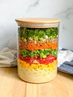 a glass jar filled with different types of vegetables