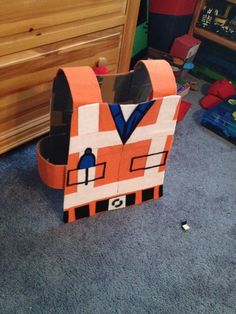 an orange construction worker paper bag sitting on the floor next to a bed and dresser