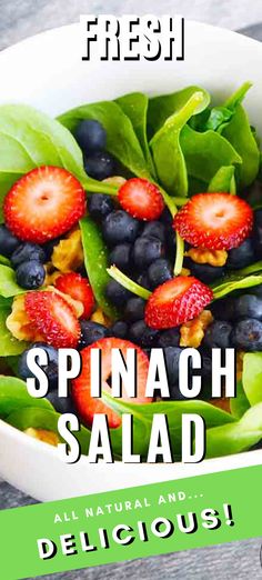 spinach salad with strawberries and blueberries in a white bowl