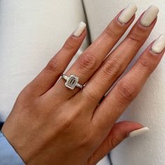 a woman's hand with white manicured nails and a ring on her finger