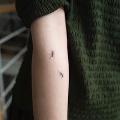 a woman's arm with three small bugs on the left side of her arm