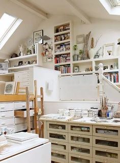 an attic kitchen with lots of shelves and drawers on the wall, along with white appliances