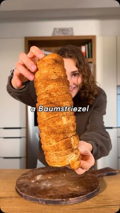 a woman holding up a large piece of bread