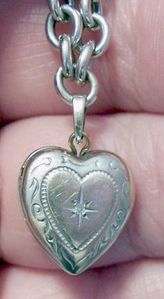 ~ Vintage 14K white gold heart locket on a 14K white gold bracelet - locket measures almost .5" tall and .5" wide at the widest point - it has a moissanite center stone inside a star and a lovely scroll design - inside are two sides for tiny photos - it closes securely. ~ Looking closely, it is etched with names on the reverse that have faded with time - it reads "Kelci and Dougie" - could possibly be buffed out - it is also hallmarked "14K" and "Tk" - the "T" and the "k" are conjoined and are t Heirloom Engraved Jewelry For Valentine's Day, Victorian Jewelry With Hallmark For Valentine's Day, Antique Double Heart Jewelry For Anniversary, Victorian Heart Charm Jewelry For Formal Occasions, Antique Hallmark Jewelry For Valentine's Day, Victorian Jewelry With Heart Charm For Valentine's Day, Victorian Heart Charm Jewelry For Valentine's Day, Double Heart Locket Jewelry For Wedding, Formal Heart-shaped Locket Jewelry