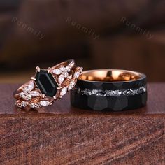 two wedding rings sitting on top of a wooden table next to each other with diamond accents