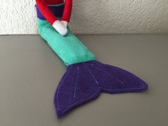 a stuffed toy mermaid sitting on top of a table