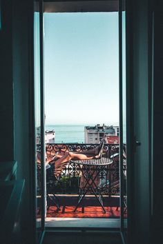 an open door leading to a balcony overlooking the ocean