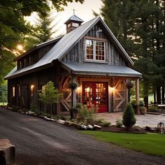 a small wooden house with a red door and windows on the front, surrounded by trees