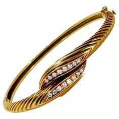 This lovely Mid-20th Century 18k yellow gold hinged bangle bracelet with diamonds exhibits true French Panache. It is deftly crafted with attention to details. At the center, sixteen brilliant cut diamonds are set and have a total approximate weight of .50ct. Overall diamond quality is G color and VS1 clarity. The plunger tongue is stamped with French touch marks that indicate the bracelet was made in France specifically for export. A high grade figure eight safety clasp offers additional security. Inside circumference is 6 1/2 inches. Gross weight 21.20 grams. Bracelet With Diamonds, Diamond Bangle Bracelet, Vintage Bangle Bracelets, Gents Ring, Vintage Bangles, Diamond Bangles Bracelet, Diamond Bangle, Hinged Bangle, Diamond Gold