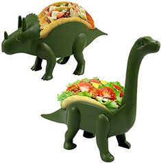 two green dinosaur shaped food holders with salad and pizza on them, one has a sandwich in it's mouth