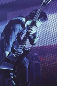 a young man playing a bass guitar on stage