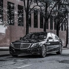 a black mercedes s - class parked on the street