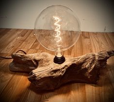 a light bulb sitting on top of a piece of driftwood next to a lamp