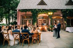 a group of people sitting around a table in front of a building