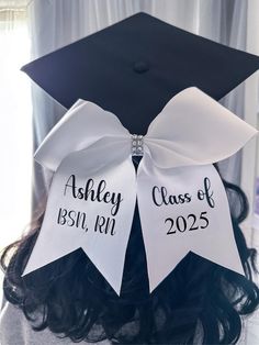 a black and white graduation cap with two ribbons