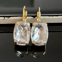 Sparkly, eye-catching, clear crystal earrings will brighten up any outfit! Precision-cut crystals and unmatched, gorgeous colors are always show-stoppers! Details: * Premium European Crystals in Setting- 1/2x3/8"(14x10mm) * Gold-plated Lever Back Earrings * Earring Length- 1"(25mm) * Earring Width- 1/2"(13mm) These earrings come in a jewelry bag and box with ribbon. The jewelry sold as a set is available through this link: https://www.etsy.com/listing/1297998802/crystal-gold-jewelry-set-swarovski?click_key=4261e81d7decf9fa62e80b15e44c0a280b180c98%3A1297998802&click_sum=00d02896&ref=shop_home_active_4&pro=1&frs=1&sts=1 These earrings come in a jewelry bag and box with ribbon. Earrings For Bride, Swarovski Crystal Drop Earrings, Clear Crystal Earrings, Drop Earrings Gold, Gold Jewelry Sets, Crystal Dangle Earrings, Bride Gift, Jewelry Bag, Crystal Set